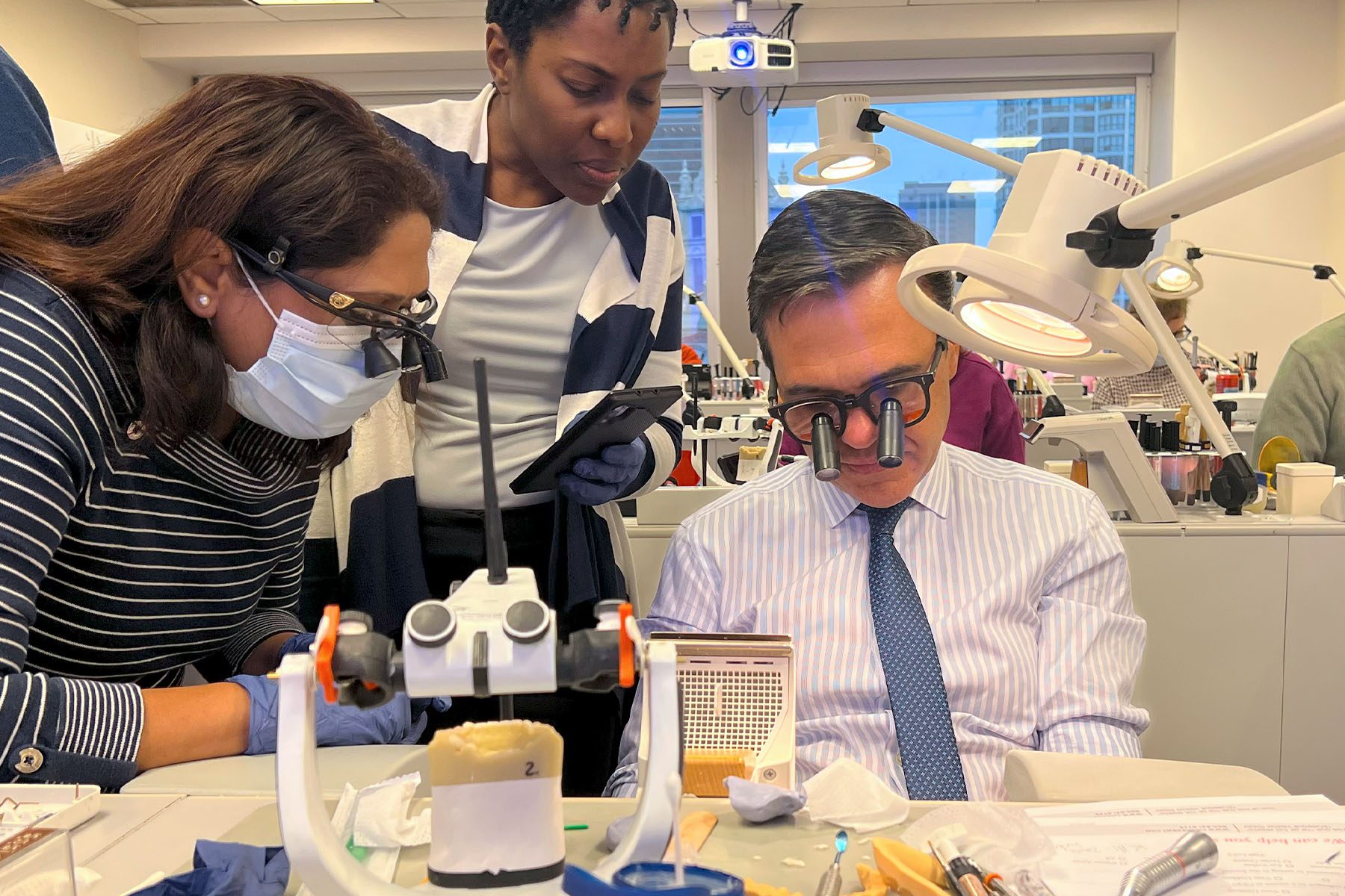 Dr. Javier Quiros shows a group of course attendees how to apply composite resin to a restoration case in his hands-on CE dental CE course.