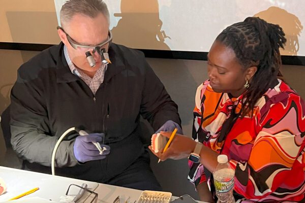 Dr. Arthur Volker guides a dental CE student through composite restoration polishing at Cosmedent's Center for Esthetic Excellence.